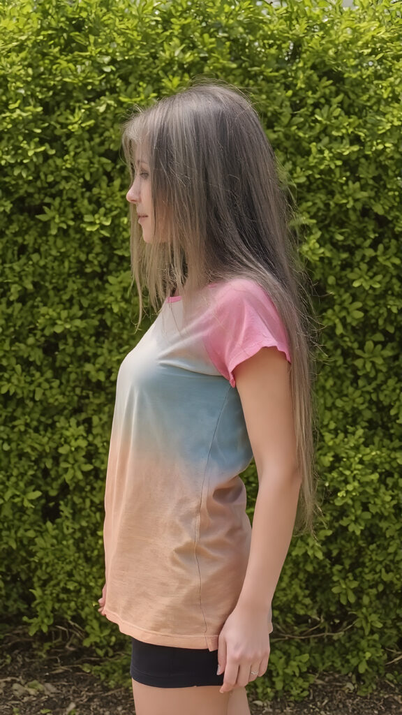 an adult girl, t-shirt in rainbow colors, black mini skirt, detailed, full body side view, straight hair fall down to her back, sunny green backdrop